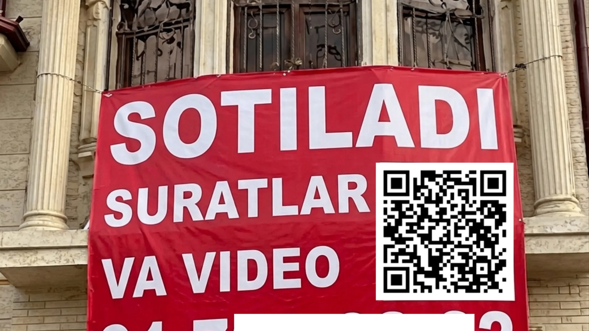 Real Soting banner hanging on a building with QR code